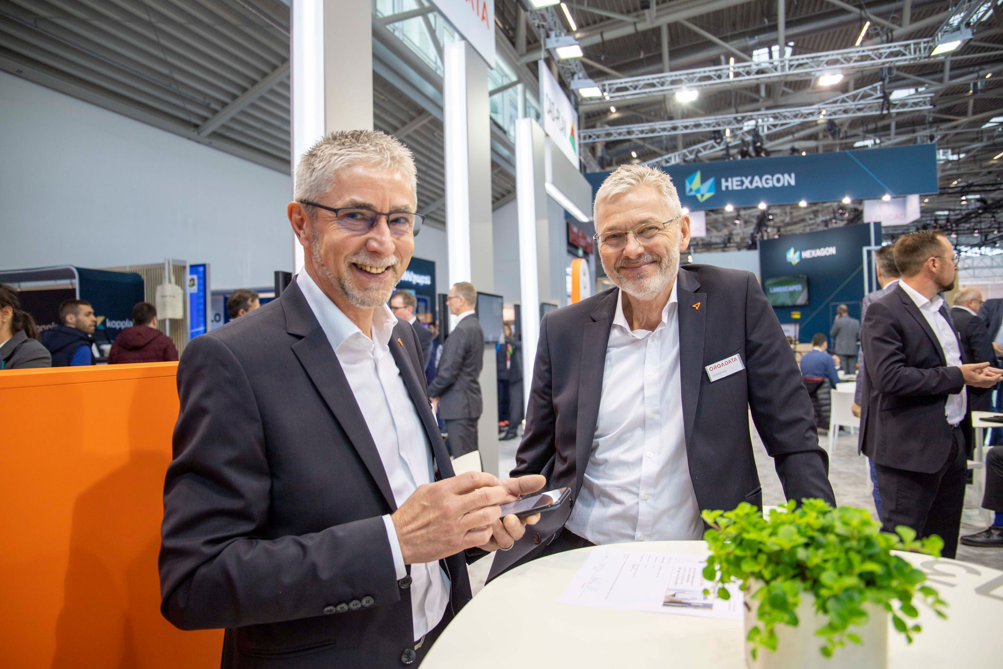 Zwei Mitarbeiter von Orgadata unterhalten sich auf dem Messestand auf der BAU